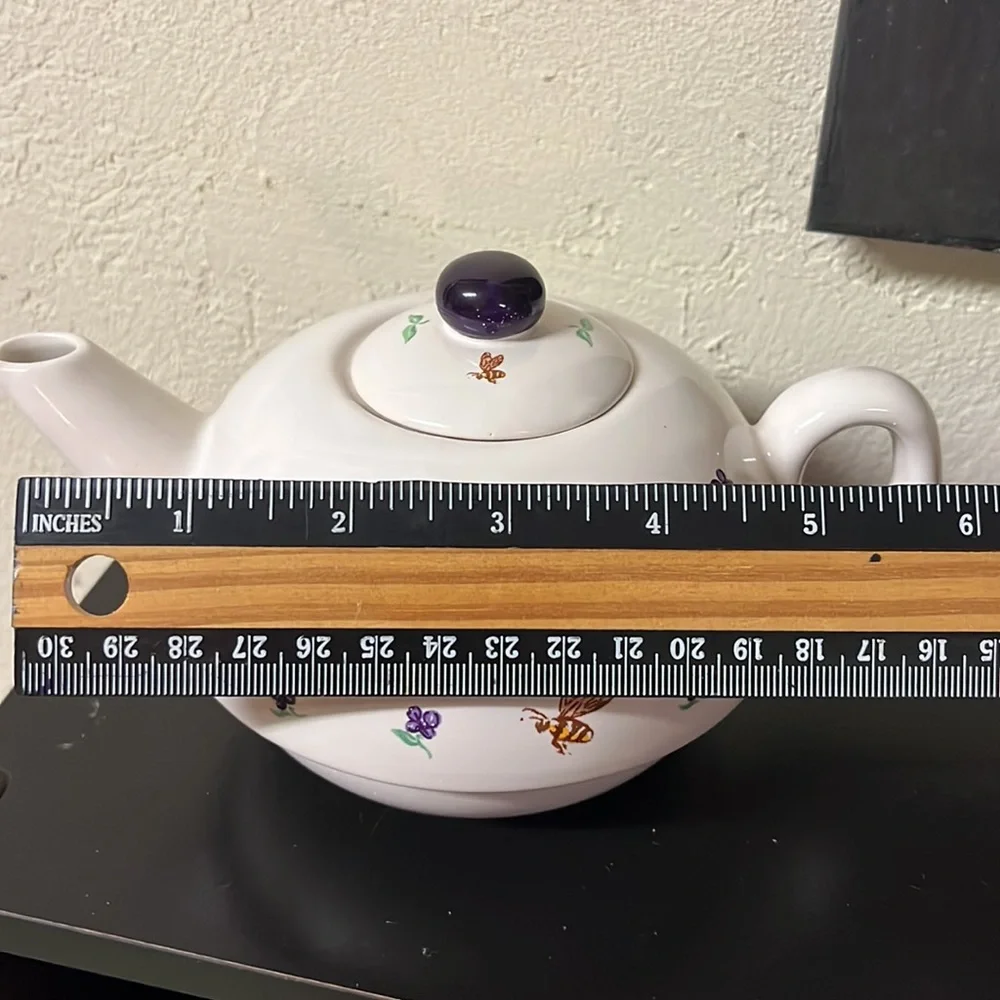 Small white teapot with violet and bee details.